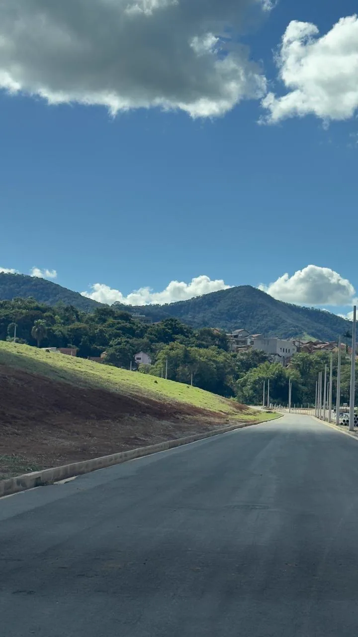 Via asfaltada do Serra Verde com meio-fio concluído e serra ao fundo